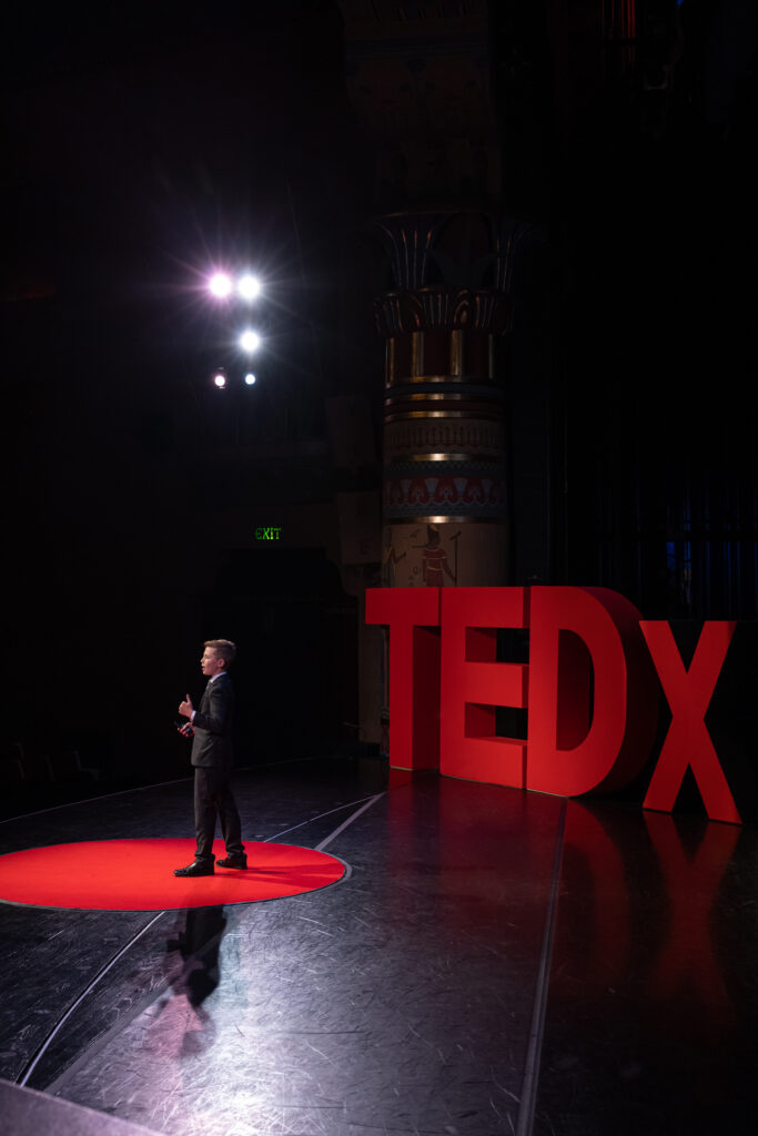 Wide stage view of Zachary Moses giving his TEDxOgden talk